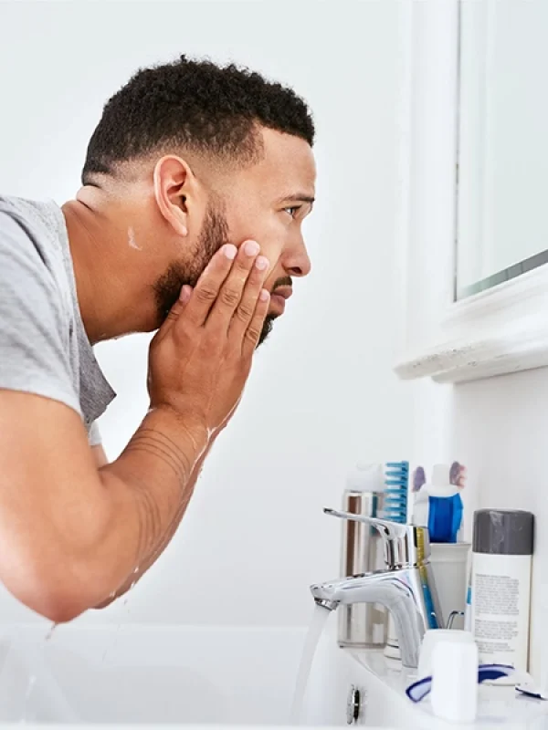 Imagen de chico lavándose la cara.