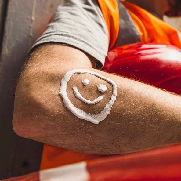 Un hombre trabajador usa cremas de hidratación para evitar dermatitis de contacto alérgica. Aplicar cremas protectoras es un hábito saludable para la piel.